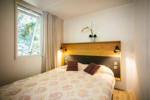 a bedroom with a bed and a window at ZEcamping 4 familial piscine chauffée club enfant animations au calme in Canet-en-Roussillon