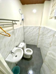 a bathroom with a white toilet and a sink at RedDoorz at Urban Hotel in Zamboanga