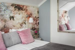 a bedroom with a mirror and a bed with pink pillows at Sävö Vandrarhem & Café in Västerljung +14 photos
