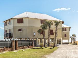 a large house with palm trees in front of it at Summer Salt 4 West by Youngs Suncoast in Orange Beach