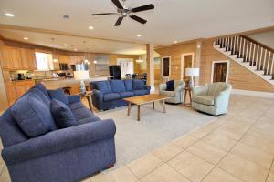 a living room with blue couches and chairs and a kitchen at Summer Salt 4 West by Youngs Suncoast in Orange Beach