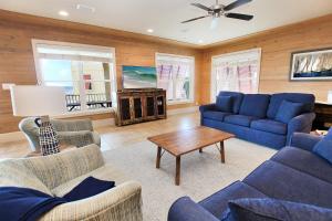 a living room with blue couches and a table at Summer Salt 4 West by Youngs Suncoast in Orange Beach