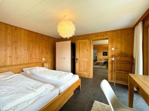 a bedroom with a bed and a table and a chandelier at Chalet apartment with Mountain View in Bettmeralp