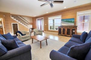 a living room with blue couches and a table at Summer Salt 4 West by Youngs Suncoast in Orange Beach +107 photos
