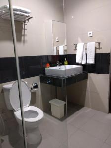 ディリにあるHotel The Ramelauの白いトイレと洗面台のあるバスルーム