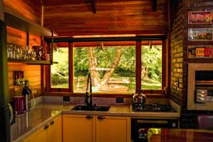 a kitchen with a sink and a window at Chalet Relaggio in Encantado