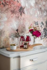 a table with a tray with glasses and a vase of flowers at Sävö Vandrarhem & Café in Västerljung