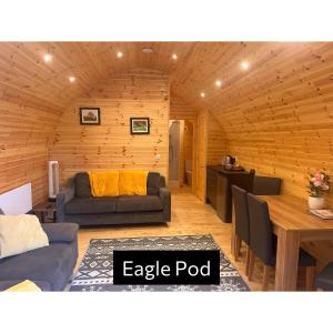 a living room with a couch and a table at Forrester Park Glamping Pods - Eagle Pod and Birdie Pods in Great Totham
