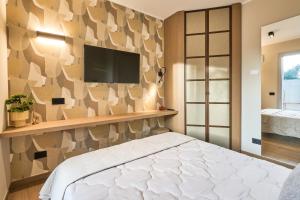 a bedroom with a bed and a tv on a wall at À la plage B in San Benedetto del Tronto