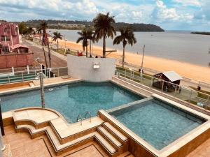 a swimming pool with a view of a beach at Hotel Vale Do Xingu in Altamira