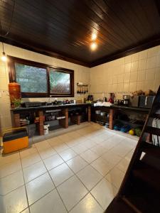 a large kitchen with a large white tile floor at Beautiful View Villa: Sea and Forest in São Francisco do Sul +44 photos