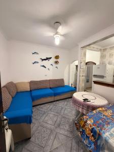a living room with a blue couch and bats on the wall at Casa de Praia Bertioga-Costa do Sol Guaratuba in Bertioga