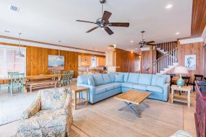 a living room with a blue couch and a table at Summer Salt West by Youngs Suncoast in Orange Beach