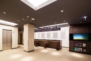 een lobby met een groot scherm tv in een gebouw bij HOTEL MYSTAYS Yokohama Kannai in Yokohama