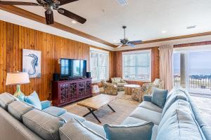 a living room with a couch and a tv at Summer Salt West by Youngs Suncoast in Orange Beach