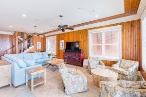 a living room with a blue couch and chairs at Summer Salt West by Youngs Suncoast in Orange Beach