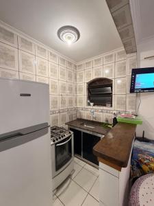 a small kitchen with a refrigerator and a stove at Casa de Praia Bertioga-Costa do Sol Guaratuba in Bertioga +28 photos