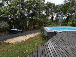 a car is parked next to a swimming pool at Beautiful View Villa: Sea and Forest in São Francisco do Sul