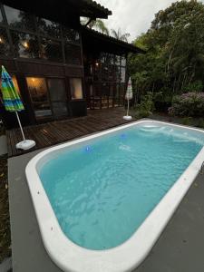 a large swimming pool in front of a house at Beautiful View Villa: Sea and Forest in São Francisco do Sul