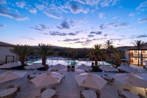 a resort with a pool and tables and umbrellas at PYRENÉUS RESIDENCE GAV Resorts in Pirenópolis