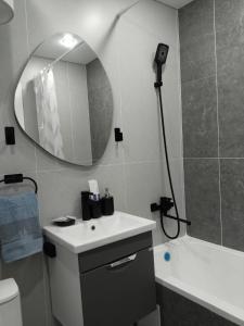 a bathroom with a sink and a mirror and a tub at Абая in Temirtaū