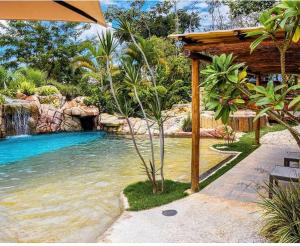 a swimming pool in a resort with a waterfall at Pousada Caminho Das Cachoeiras in Sao Jorge