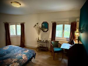 una camera da letto con un letto, una scrivania e due finestre di Logies Het Koetshuis a Herentals