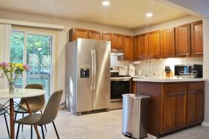 a kitchen with a stainless steel refrigerator and a table at Exclusive 2B1B Prime Location in Sylvan Lake +9 photos