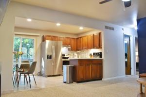 a kitchen with wooden cabinets and a stainless steel refrigerator at Exclusive 2B1B Prime Location in Sylvan Lake