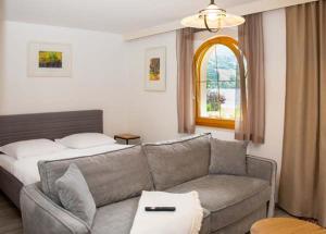 a living room with a couch and a window at Fischerhof Appartements in Feld am See