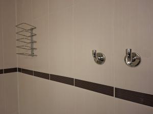 a shower with two silver handles and a shelf at Comfort Hotel Orleans Saran in Saran +39 photos