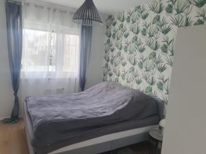 a bedroom with a bed with a floral wallpaper at Apartament Number One NOVA WOZOWNIA in Leszno