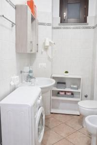 a white bathroom with a washing machine in it at Casa Ruicella in Crotone +6 photos