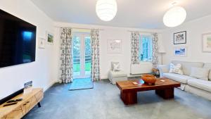 a living room with a couch and a tv at The Tidal Shack - Part of the The Bay Filey Holiday Village with pool, gym and direct beach access, pub, restaurant, tennis and meadows walks in Reighton