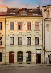 ein großes gelbes Gebäude mit Fenstern an einer Straße in der Unterkunft Upper Apart in Cieszyn