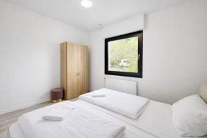 a bedroom with two white beds and a window at Villa Heusenstamm in Heusenstamm