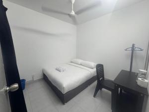 a bedroom with a bed and a chair and a desk at Raub Colonial Homestay in Raub