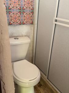 a white toilet in a bathroom with a shower at ecopolis birds lodge in El Queremal +157 photos