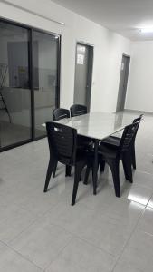 a black table and chairs in a room with glass at Raub Colonial Homestay in Raub