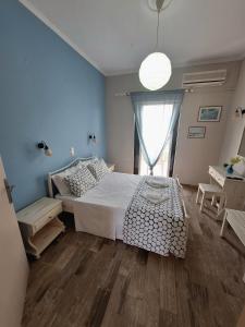 a bedroom with a white bed and a window at Antzela Apartments in Sidari