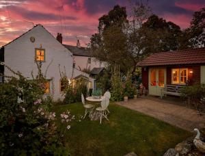 a backyard with a table and chairs and a house at Wentbridge House Hotel in Pontefract