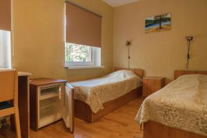 a bedroom with two beds and a window at Alutaguse Tervisespordikeskuse Peamaja in Vasavere
