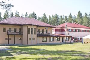 a large building with a lawn in front of it at Alutaguse Tervisespordikeskuse Peamaja in Vasavere