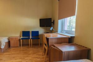a room with a desk and two blue chairs at Alutaguse Tervisespordikeskuse Peamaja in Vasavere