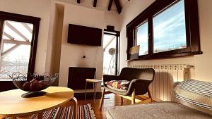 a living room with a couch and a chair and a table at Mountain View Retreat Mionica in Kosjeric