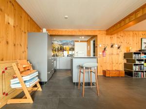 a kitchen with wooden walls and a counter and a stool at Chalet apartment with Mountain View in Bettmeralp