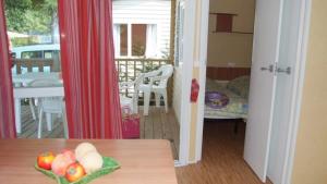 a room with a table with a bowl of fruit on it at ZEcamping 3 étoiles animations à 2 km du lac de Sainte Croix in Moustiers-Sainte-Marie
