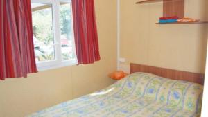 a bedroom with a bed and a window at ZEcamping 3 étoiles animations à 2 km du lac de Sainte Croix in Moustiers-Sainte-Marie