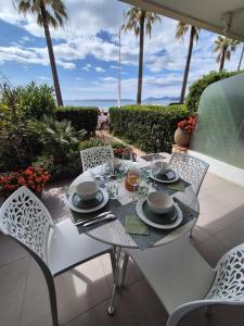 a table and chairs on a patio with the ocean at Juan Plage in Juan-les-Pins