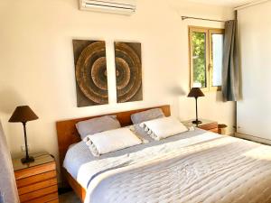 a bedroom with a large white bed with two lamps at Villa Pierretti - Vue mer Panoramique in Coti-Chiavari